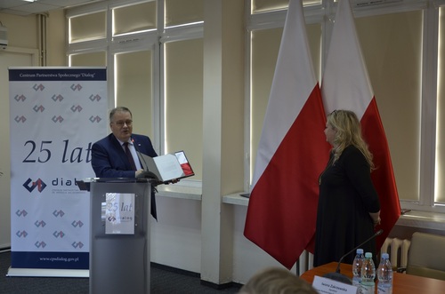 Andrzej Dera Sekretarz Stanu w Kancelarii Prezydenta RP przekazuje flagę państwową z wpisem od Prezydenta RP